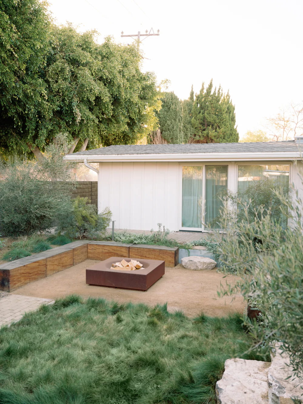 Paloform Caldera Fire Pit sits naturally at the heart of this sunken garden